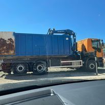 Un camión volquete azul está estacionado al lado de un camión volquete naranja.