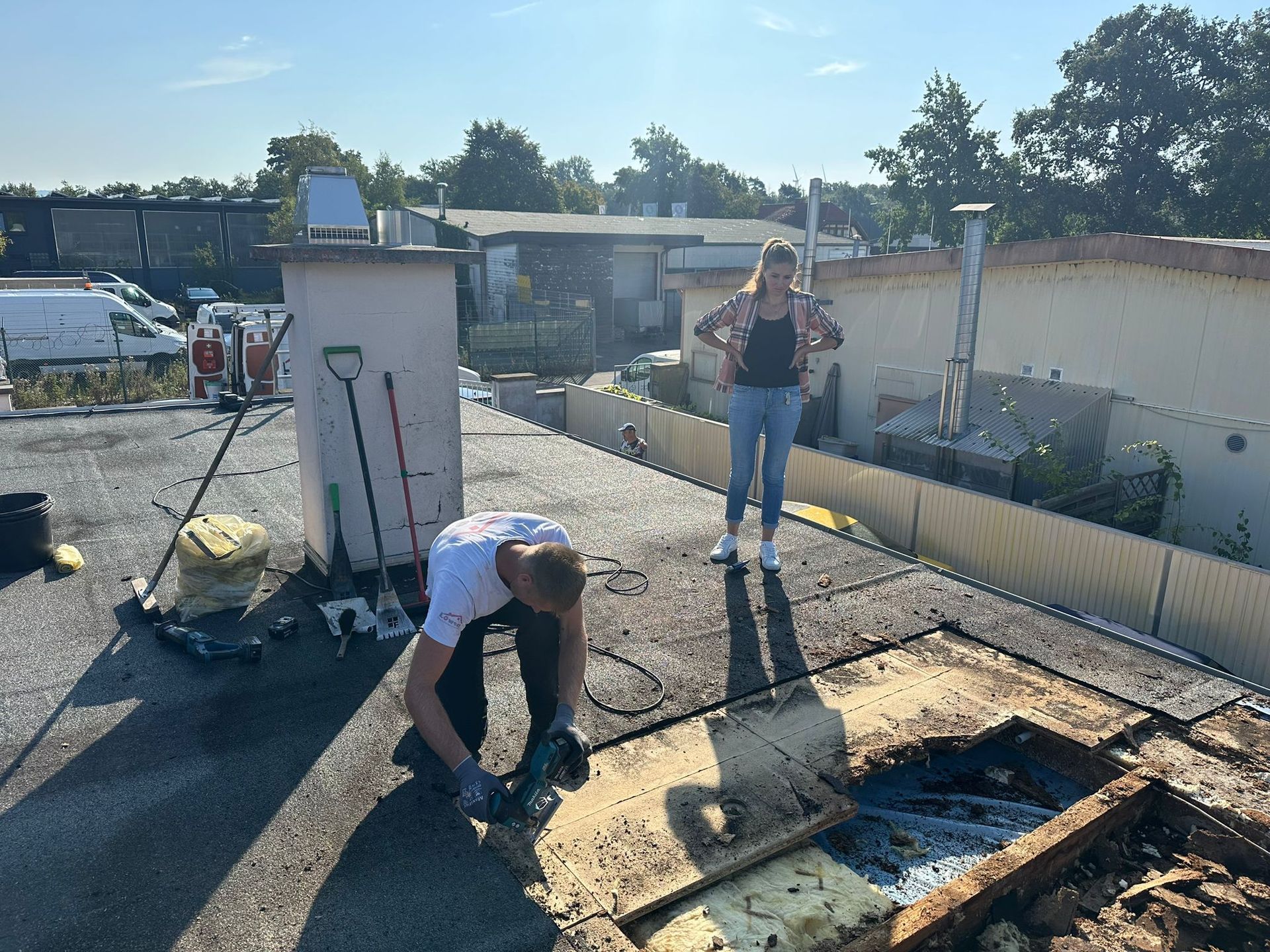 Ein Mann und eine Frau arbeiten auf einem Dach.