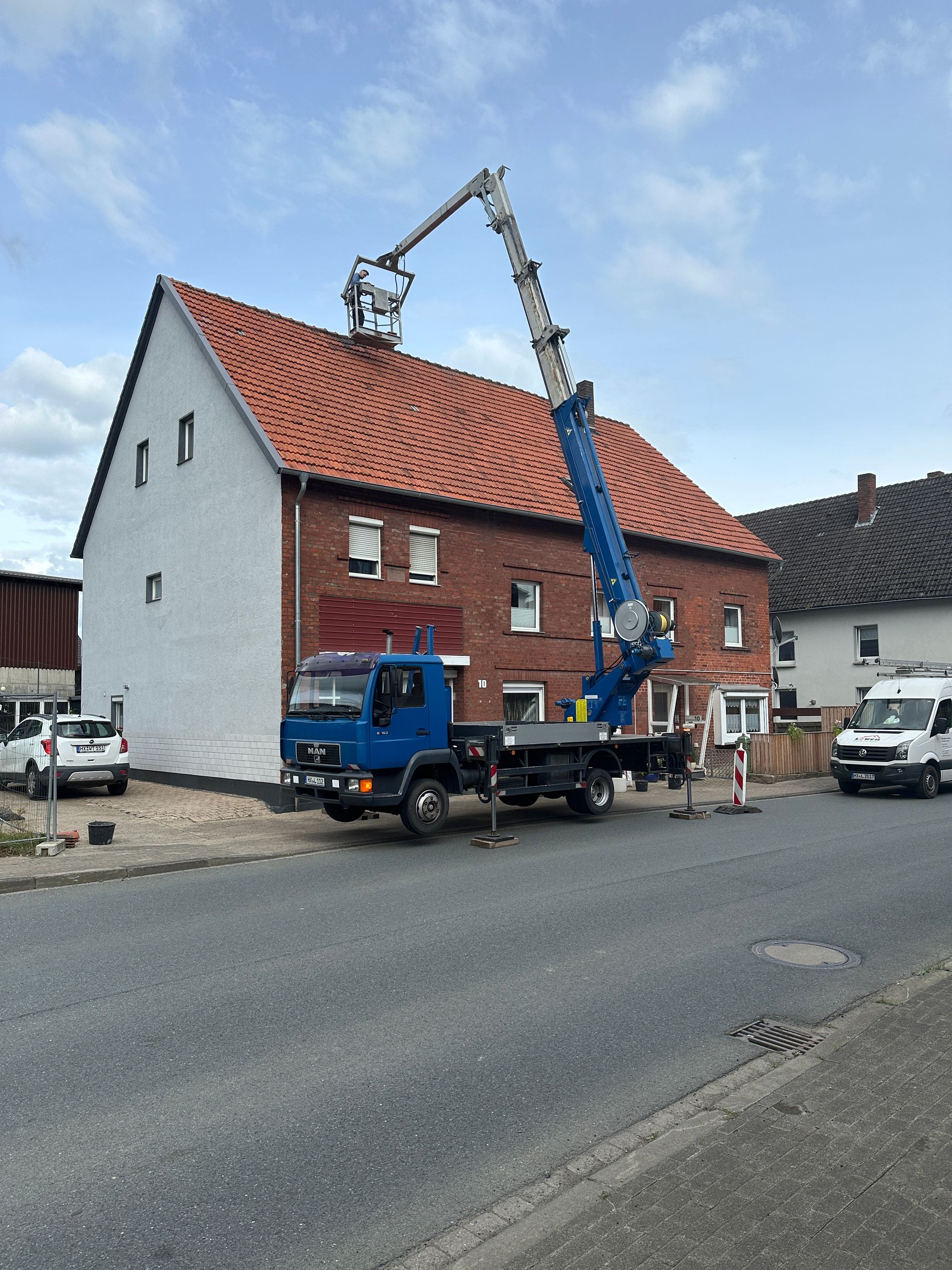 Ein blauer LKW steht vor einem Backsteingebäude