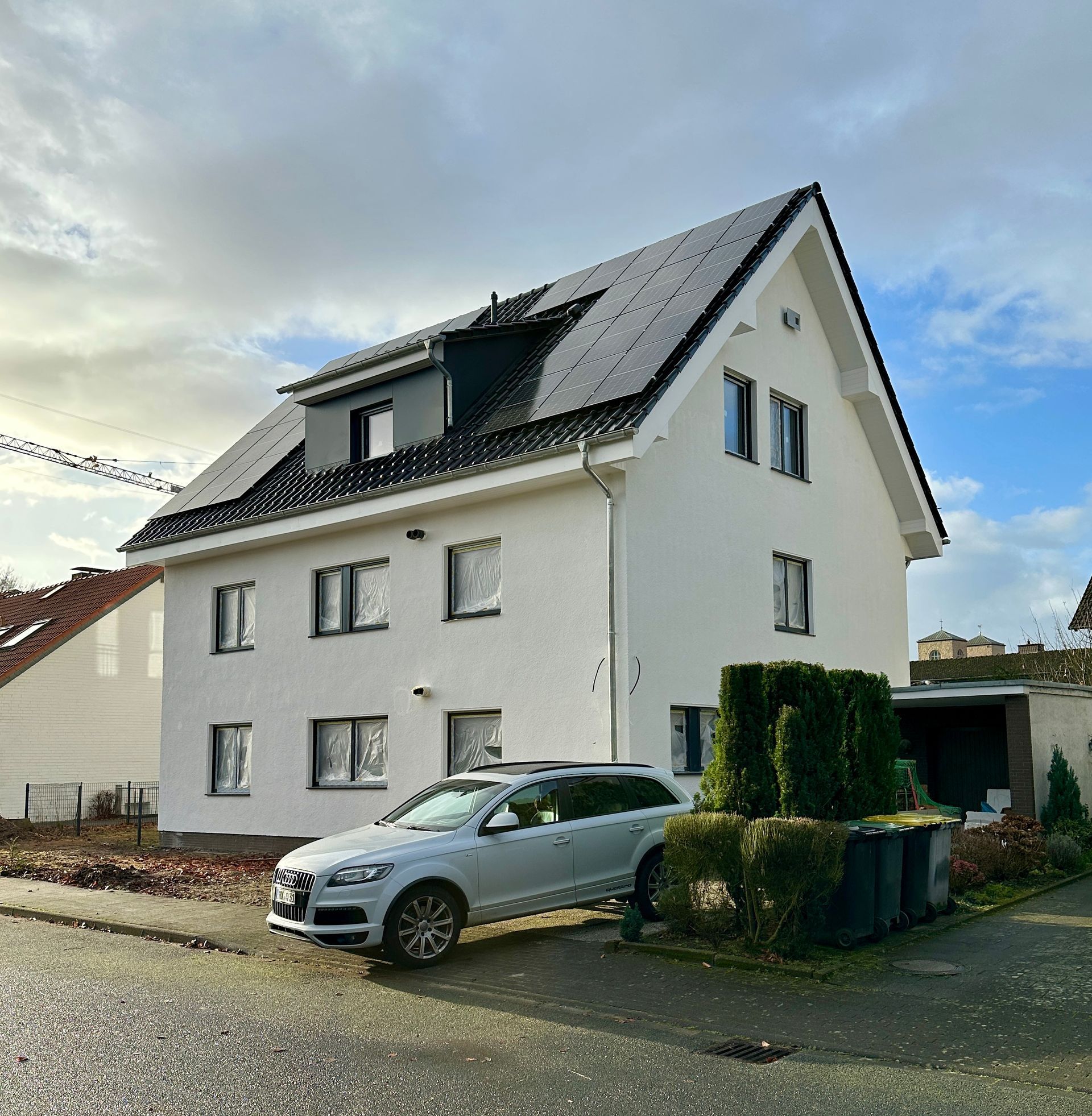 Ein weißes Haus mit einem davor geparkten Auto