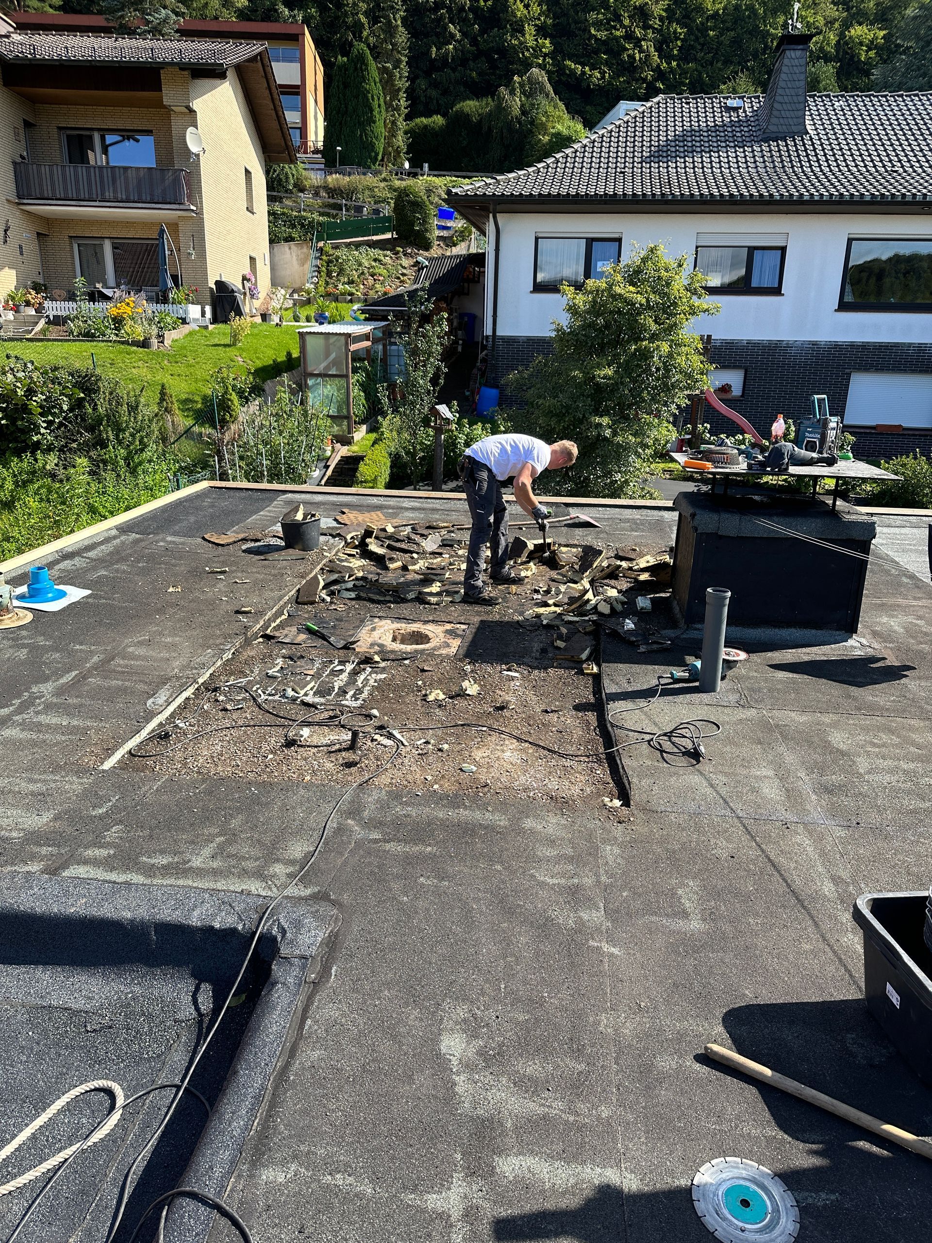 Ein Mann arbeitet auf dem Dach eines Hauses.