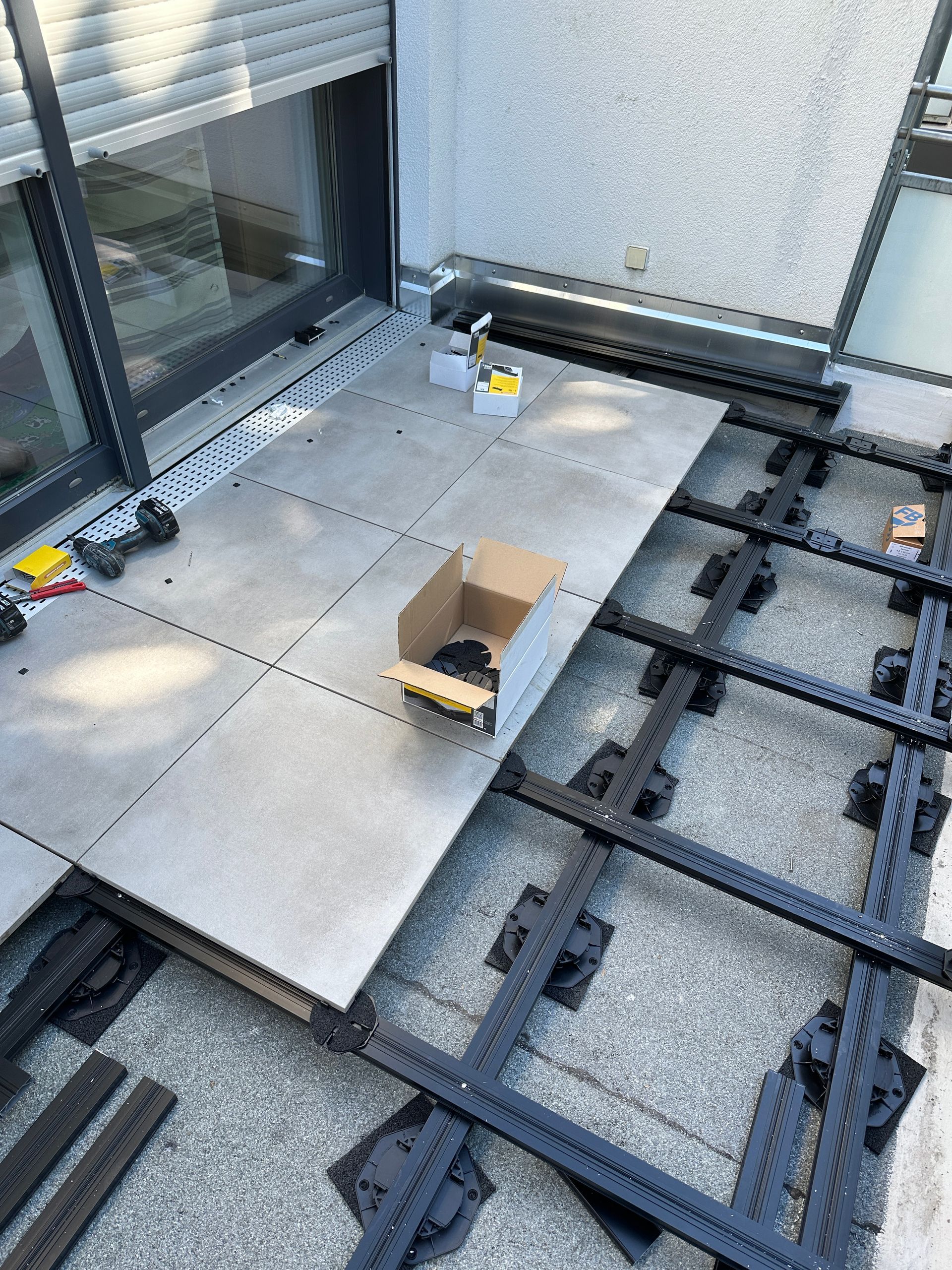 Auf einem Betonboden neben einem Fenster steht eine Kiste.