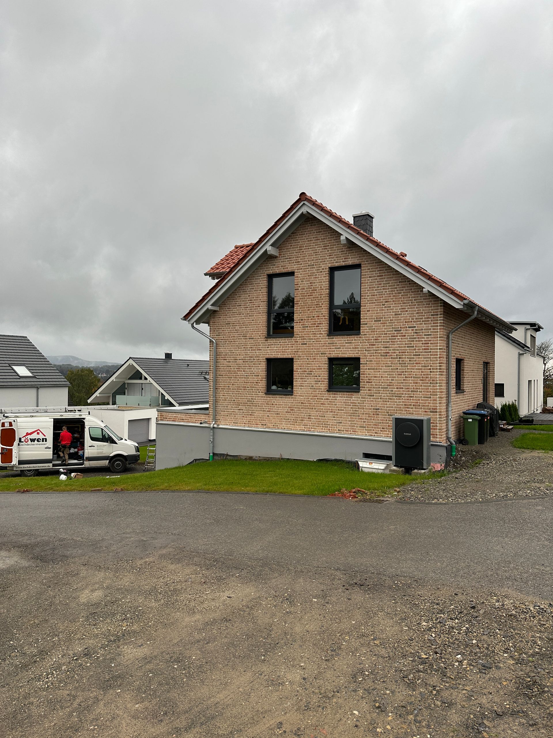 Ein weißer Lieferwagen steht vor einem Haus