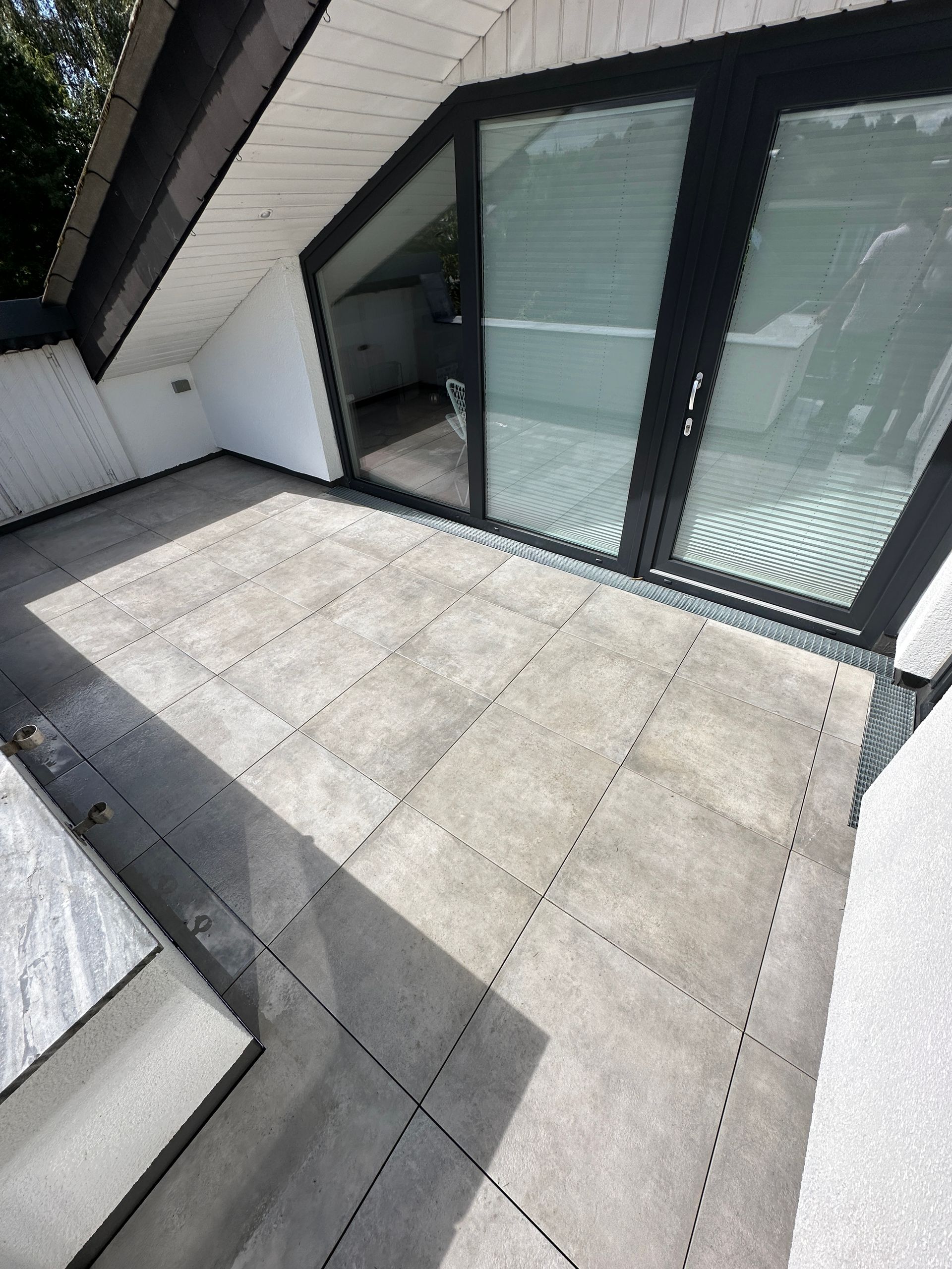 Ein Balkon mit Glasschiebetür und Treppe