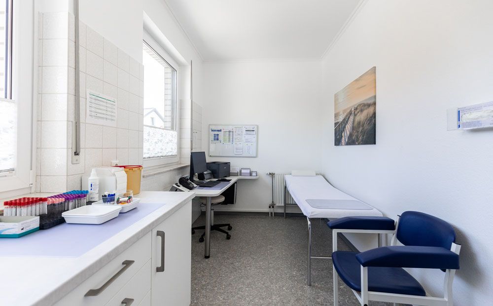 Eine Arztpraxis mit einem Tisch, Stühlen und einem Computer.