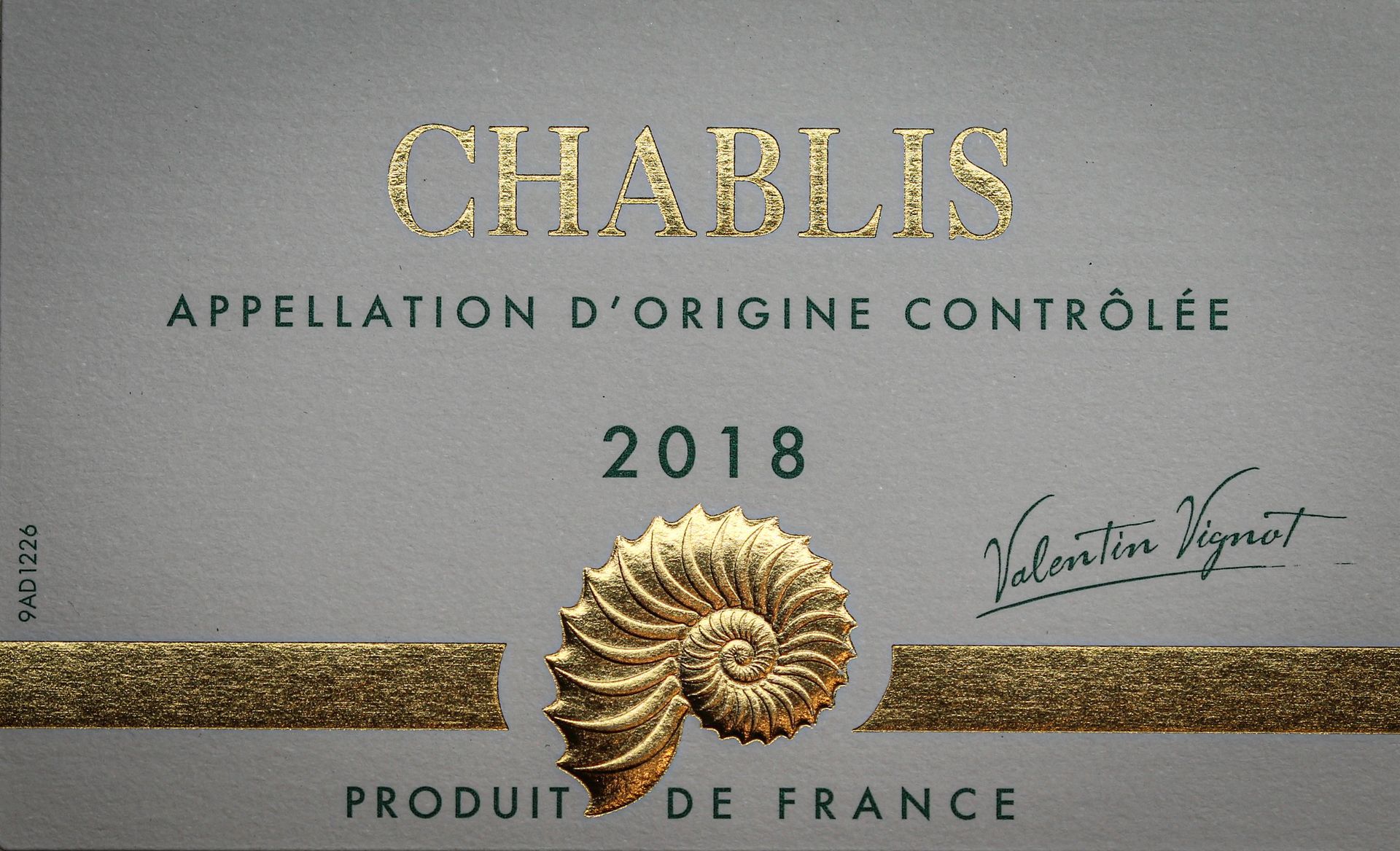 Étiquette avec des écritures et motifs dorés pour une bouteille de vin Chablis