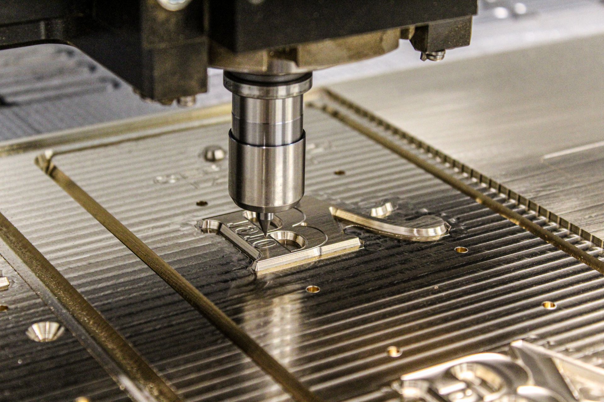 Machine de précision en train de graver une pièce sur du métal doré
