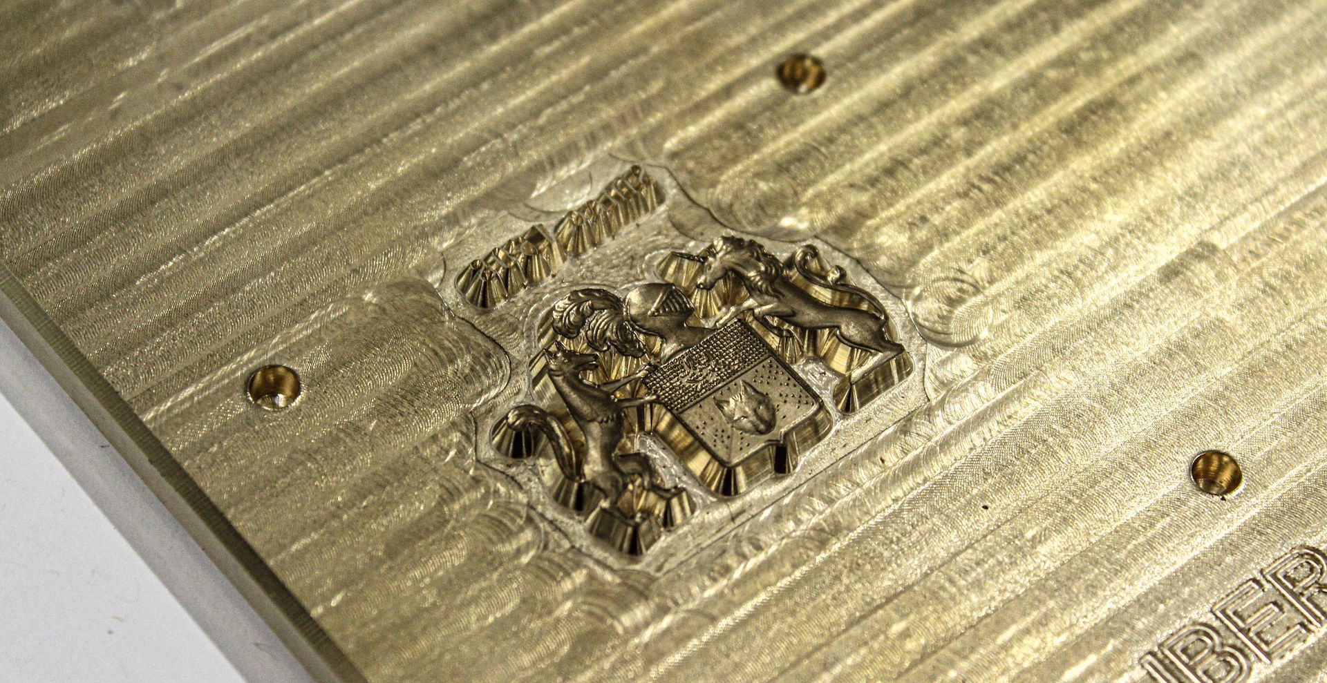 Armoiries gravées avec précision sur un métal doré