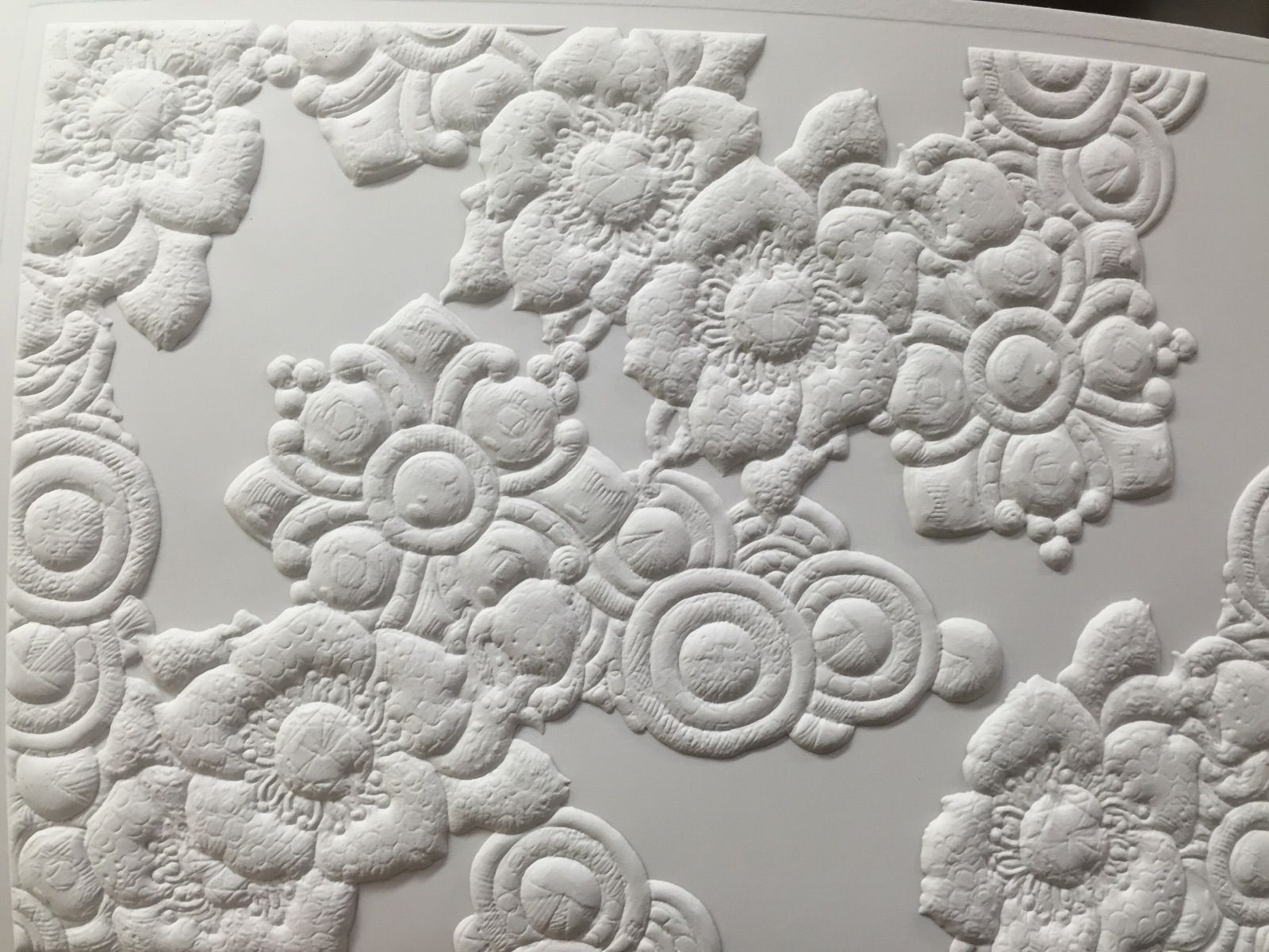 Impression en relief sur du papier avec des formes arrondies et des fleurs