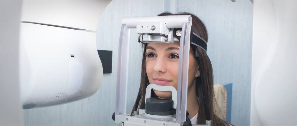 Eine Frau unterzieht sich in einer Arztpraxis einer Augenuntersuchung mit einem Spezialgerät.