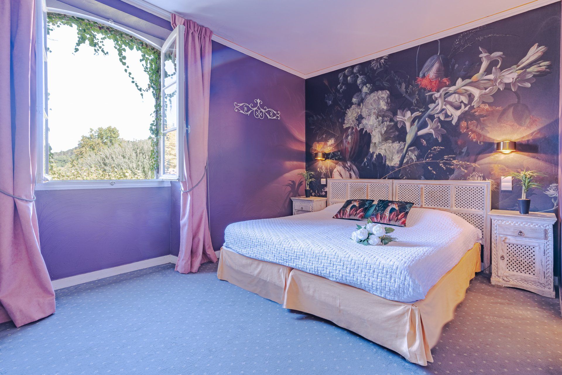 Chambre cosy avec fresque florale, rideaux roses et vue sur la nature
