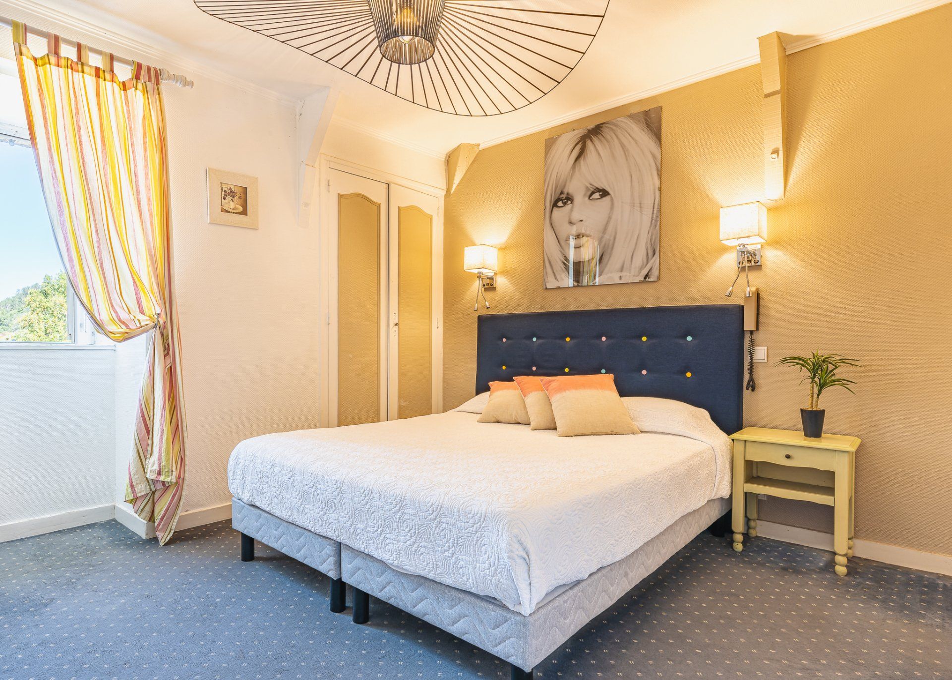 Chambre avec lit double, tête de lit bleue et décoration murale artistique