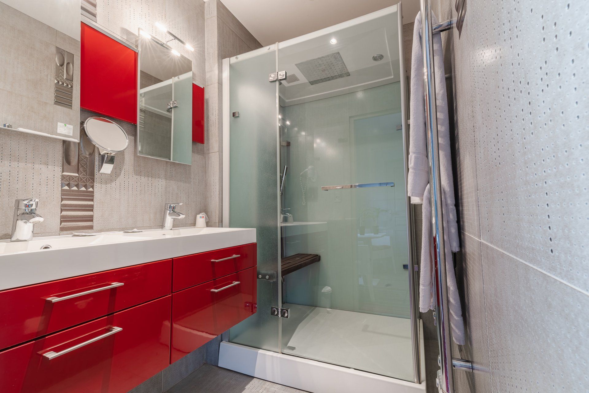 Salle de bains moderne avec douche à l’italienne et meubles rouges