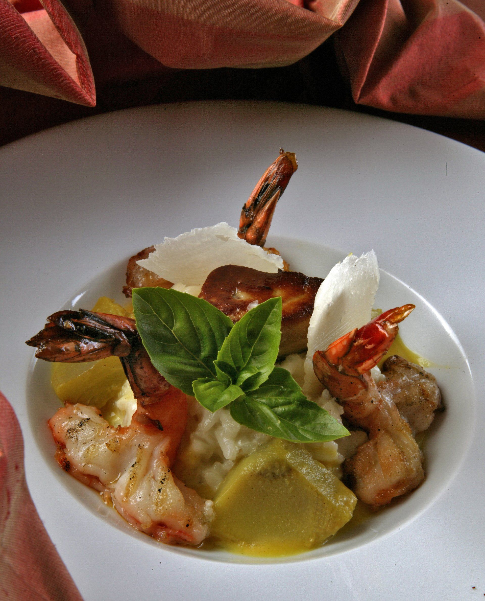 Plat composé d'écrevisses, de cœurs d'artichauts et de feuilles de basilic frais