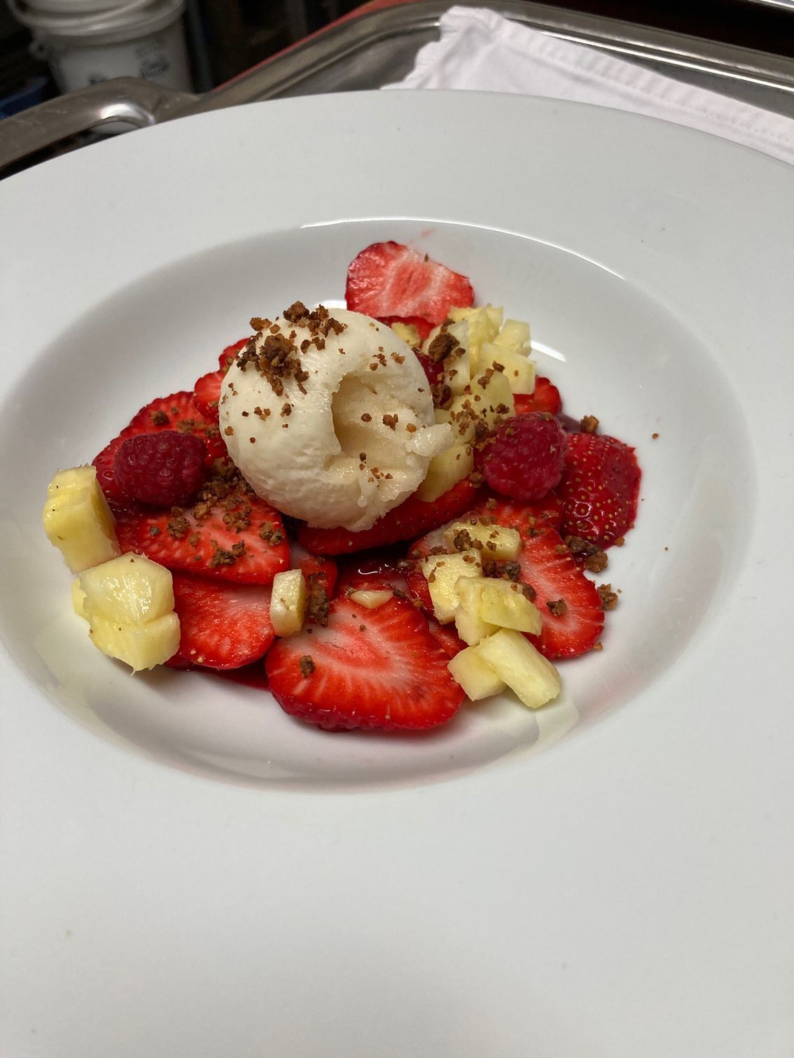 Assiette de dessert avec des boules de glace entourées de tranches de fraises et de bananes
