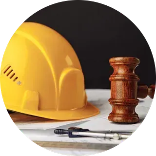Sobre una mesa hay un casco amarillo y un mazo de juez de madera.