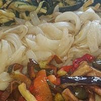Un primer plano de un plato de comida con fideos y verduras.