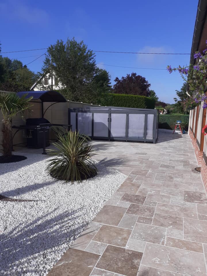 Jardin avec terrasse en pierre et piscine couverte