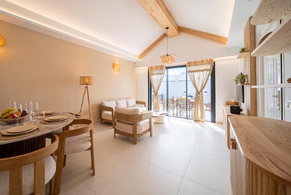Salón y comedor diáfanos con vigas de madera y salida a la terraza