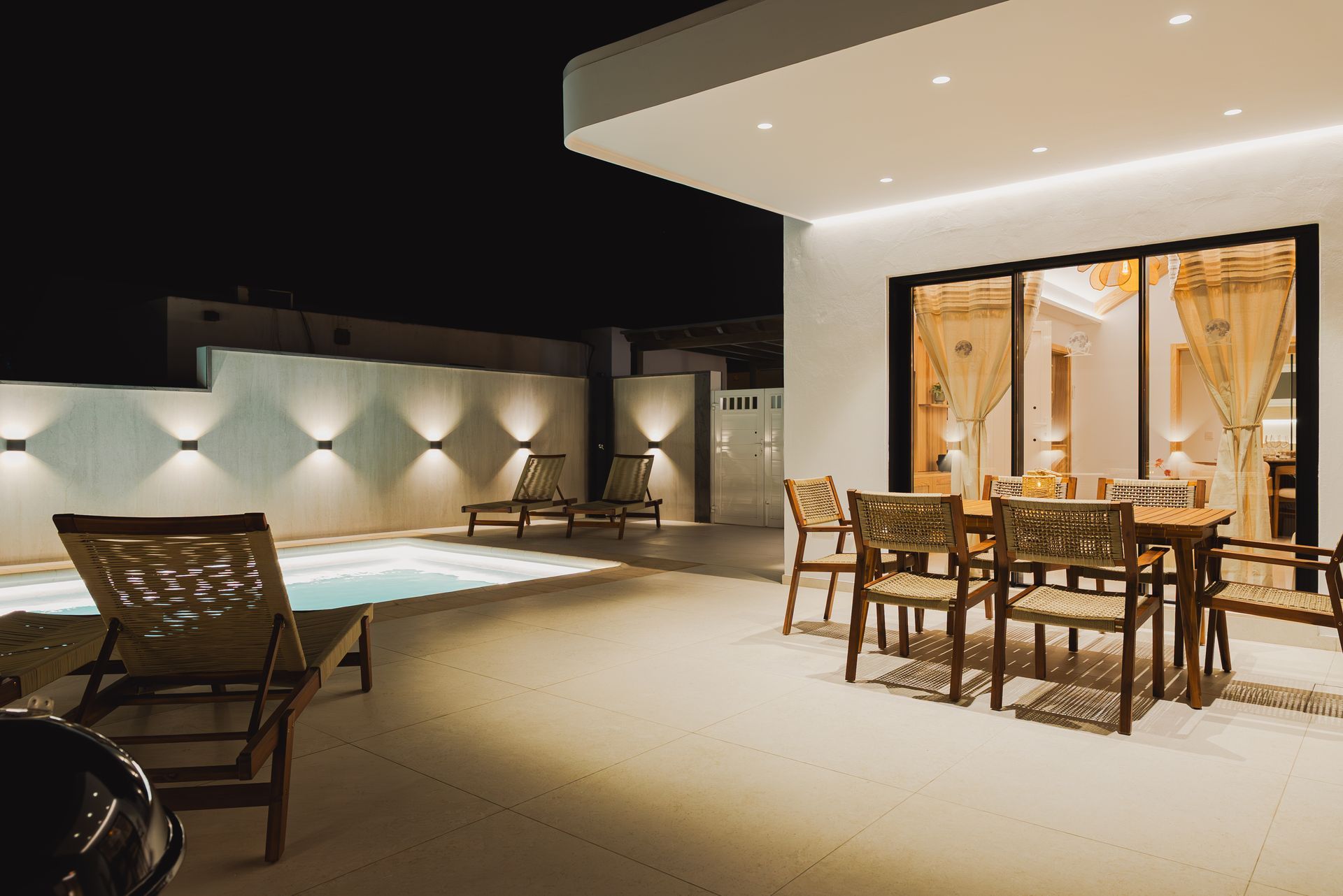 Terraza de Villa Moon de noche con piscina climatizada, tumbonas y comedor exterior