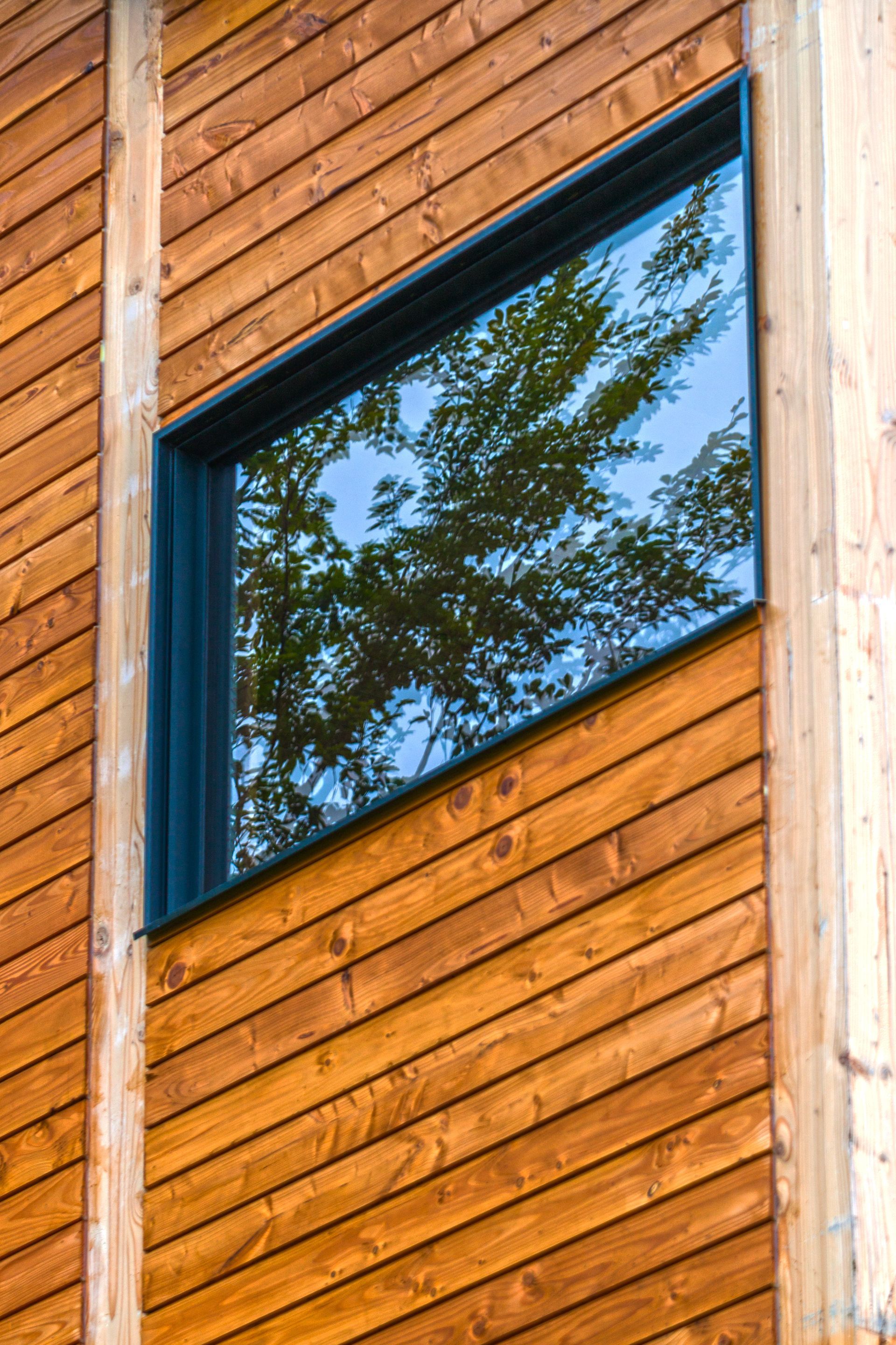 Fenêtre alu sur façade en bois