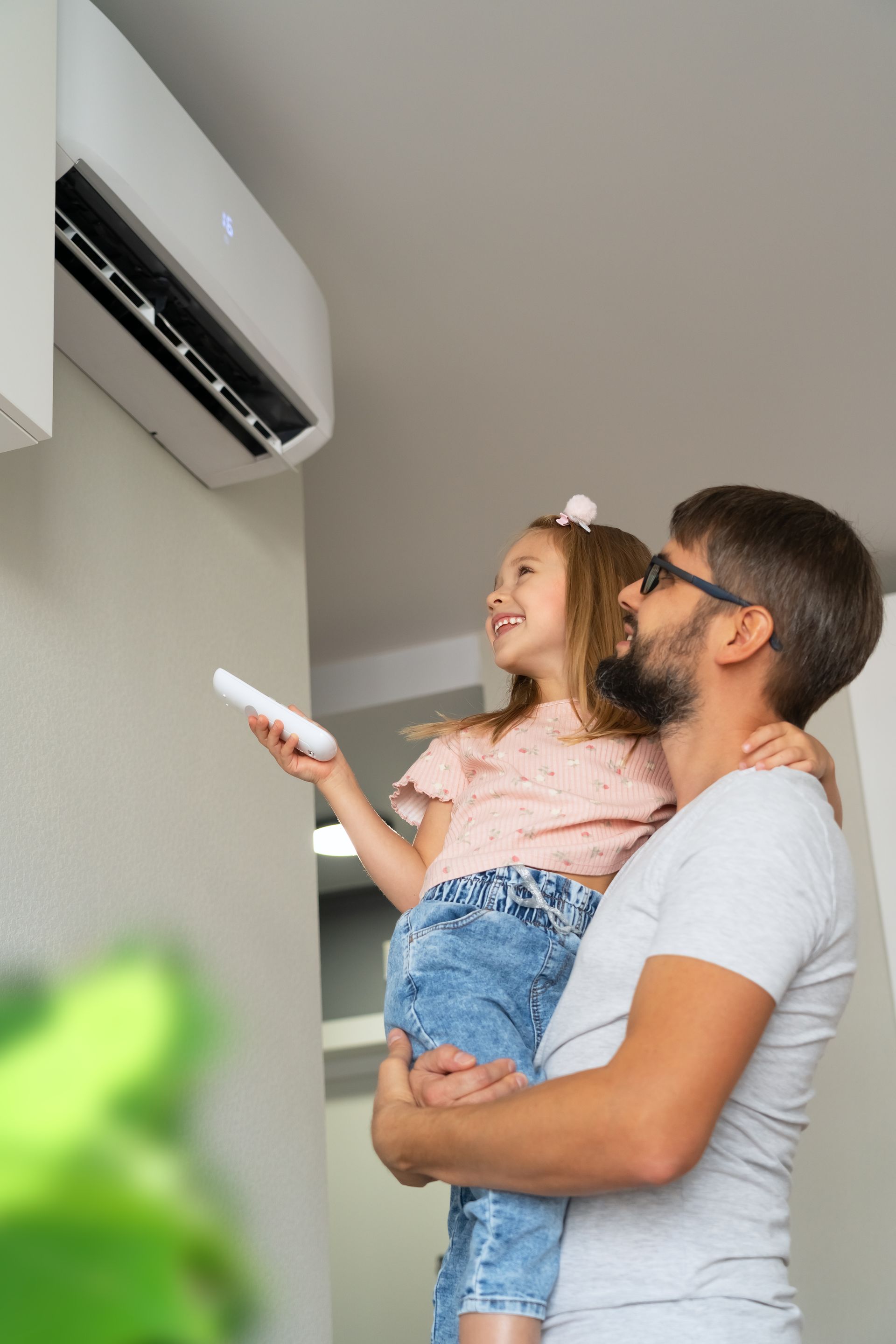 Famille utilisant une télécommande pour mettre en marche la climatisation.