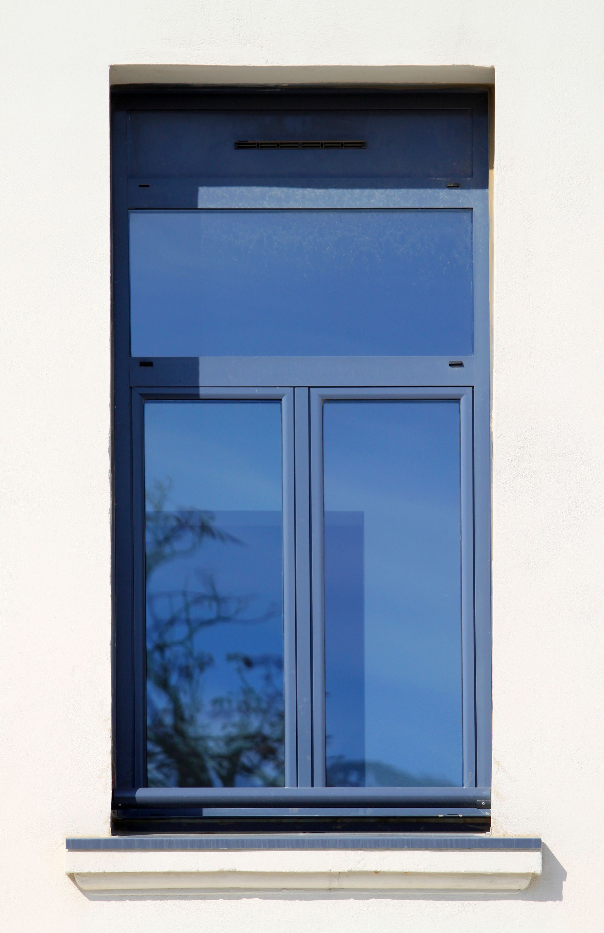 Fenêtre aluminium à deux vantaux installée sur une façade de maison moderne.