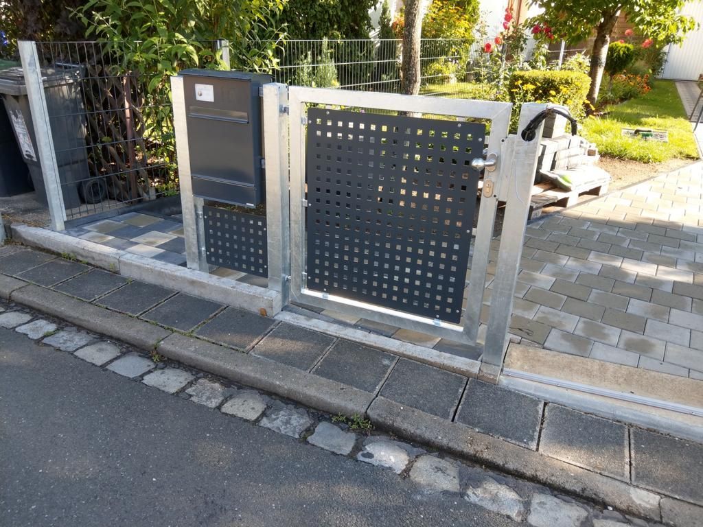 Metallzaun mit Tor und Briefkasten
