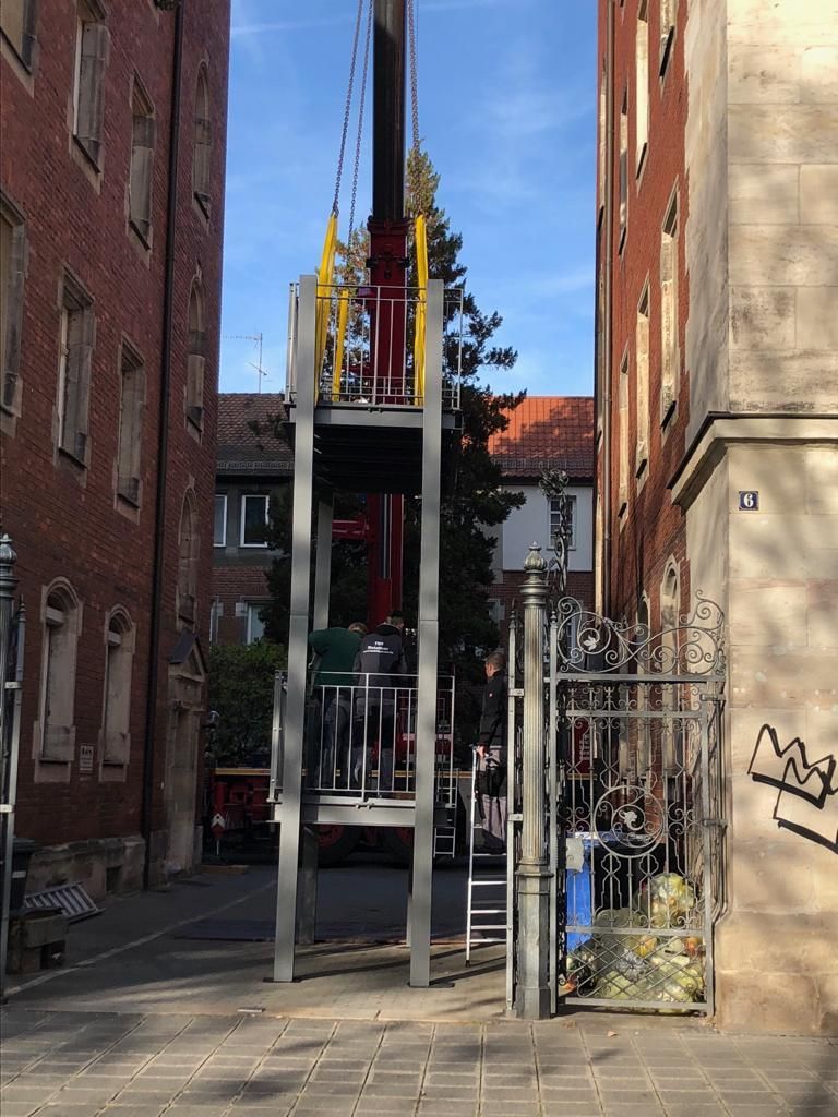Anlieferung und Montage von neuen Balkonen aus Metall in einer kleinen Gasse