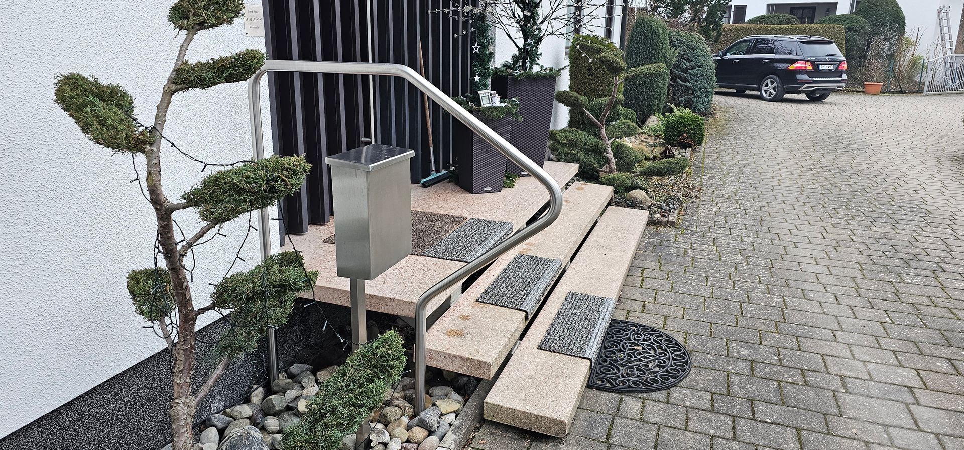 Steintreppen mit Metallgeländer und Briefkasten für einen Hauseingang