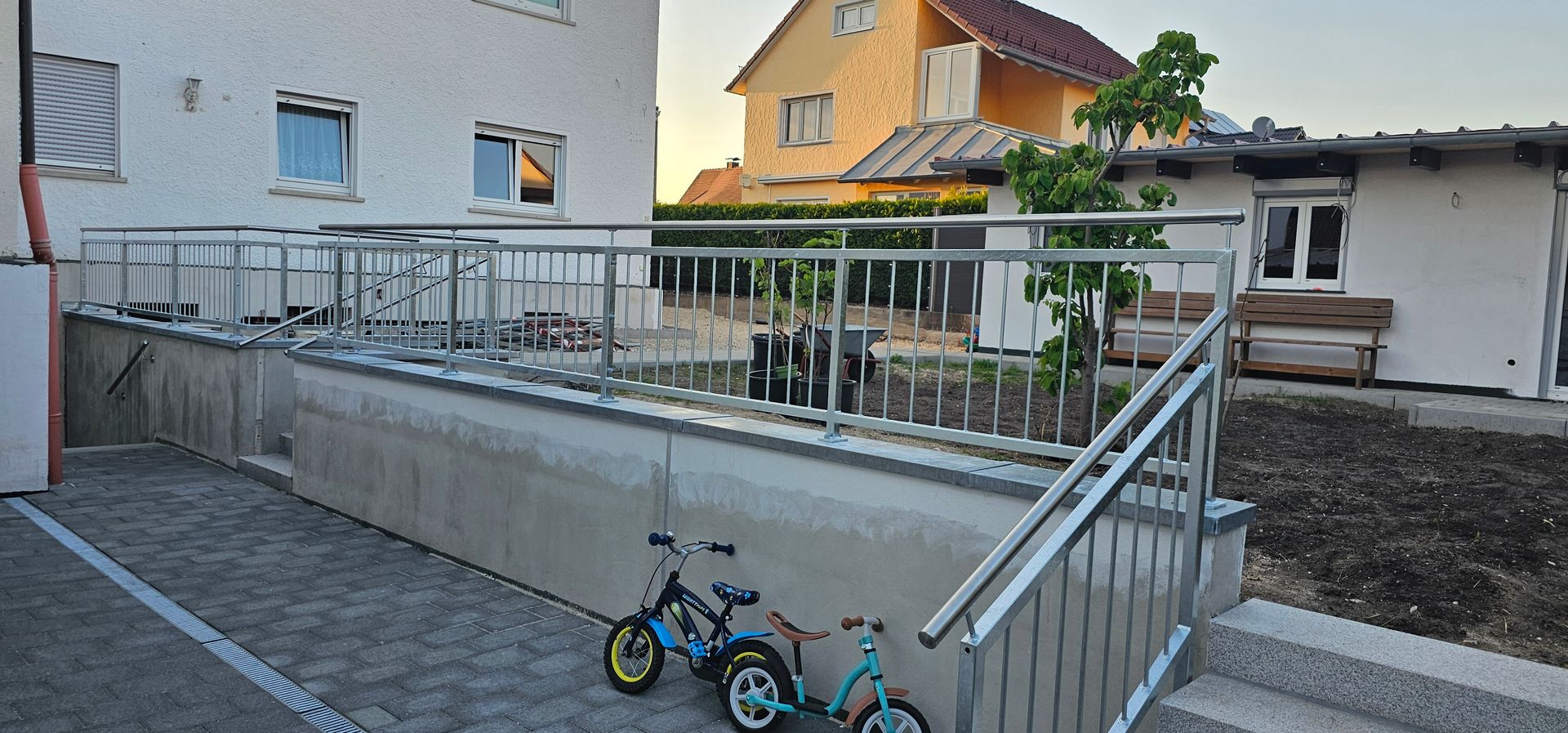 Steintreppe und Metallgeländer zur Terrasse eines Hauses