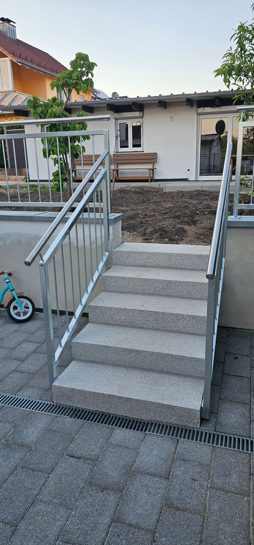 Steintreppe und Metallgeländer zur Terrasse eines Hauses