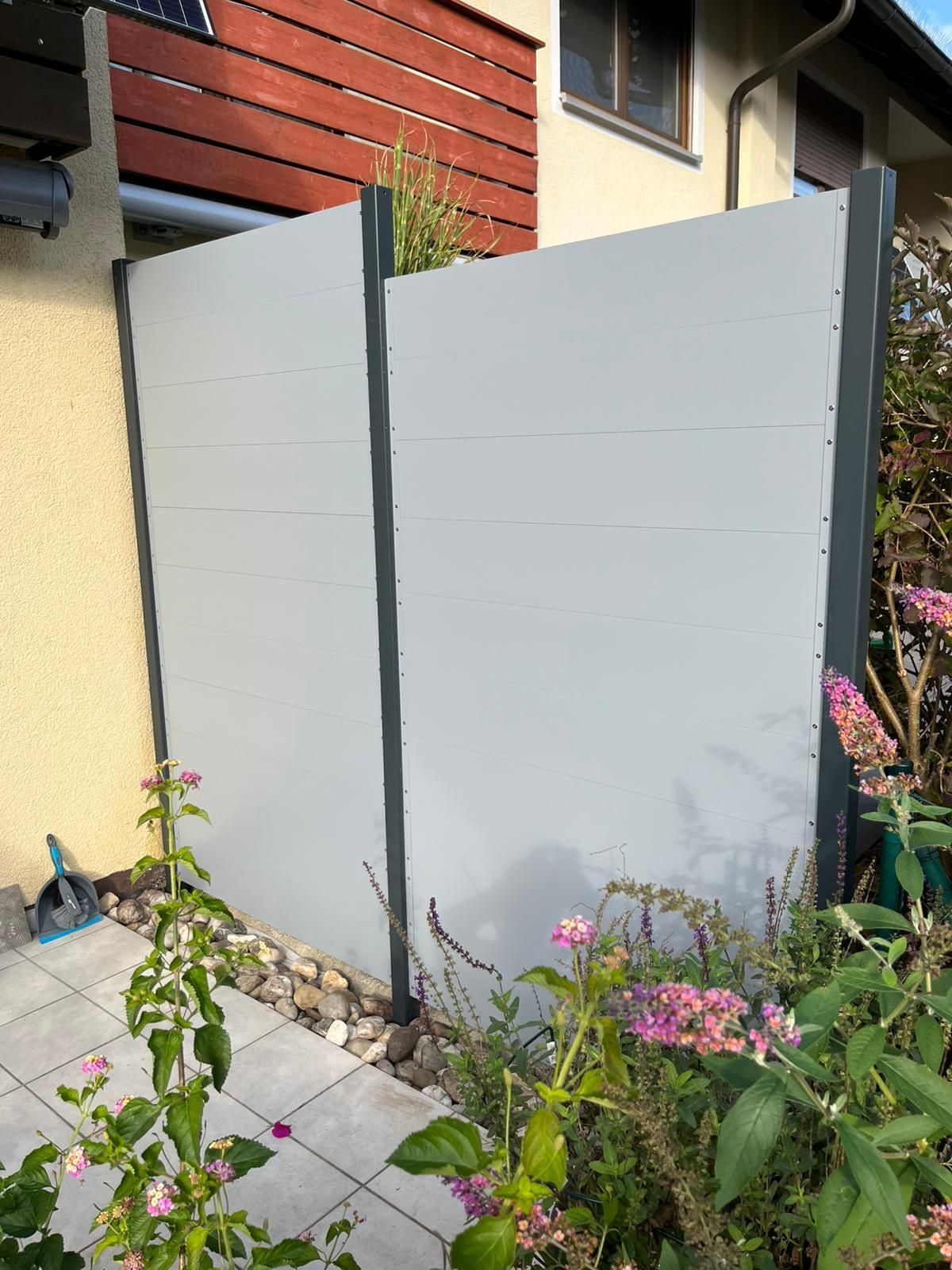 Sichtschutz einer Terrasse mit Blumenbeet