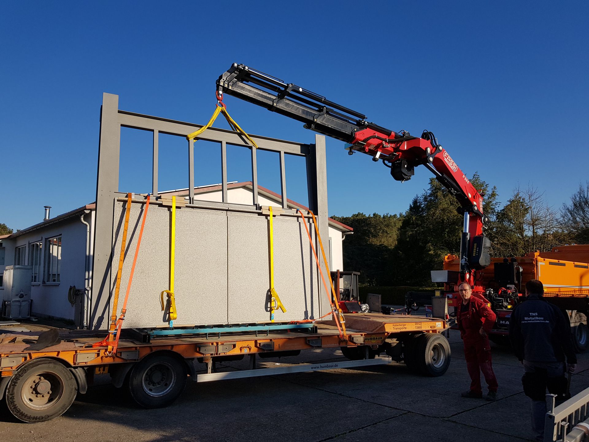 Anlieferung eines Zaunes aus Metall und Stein