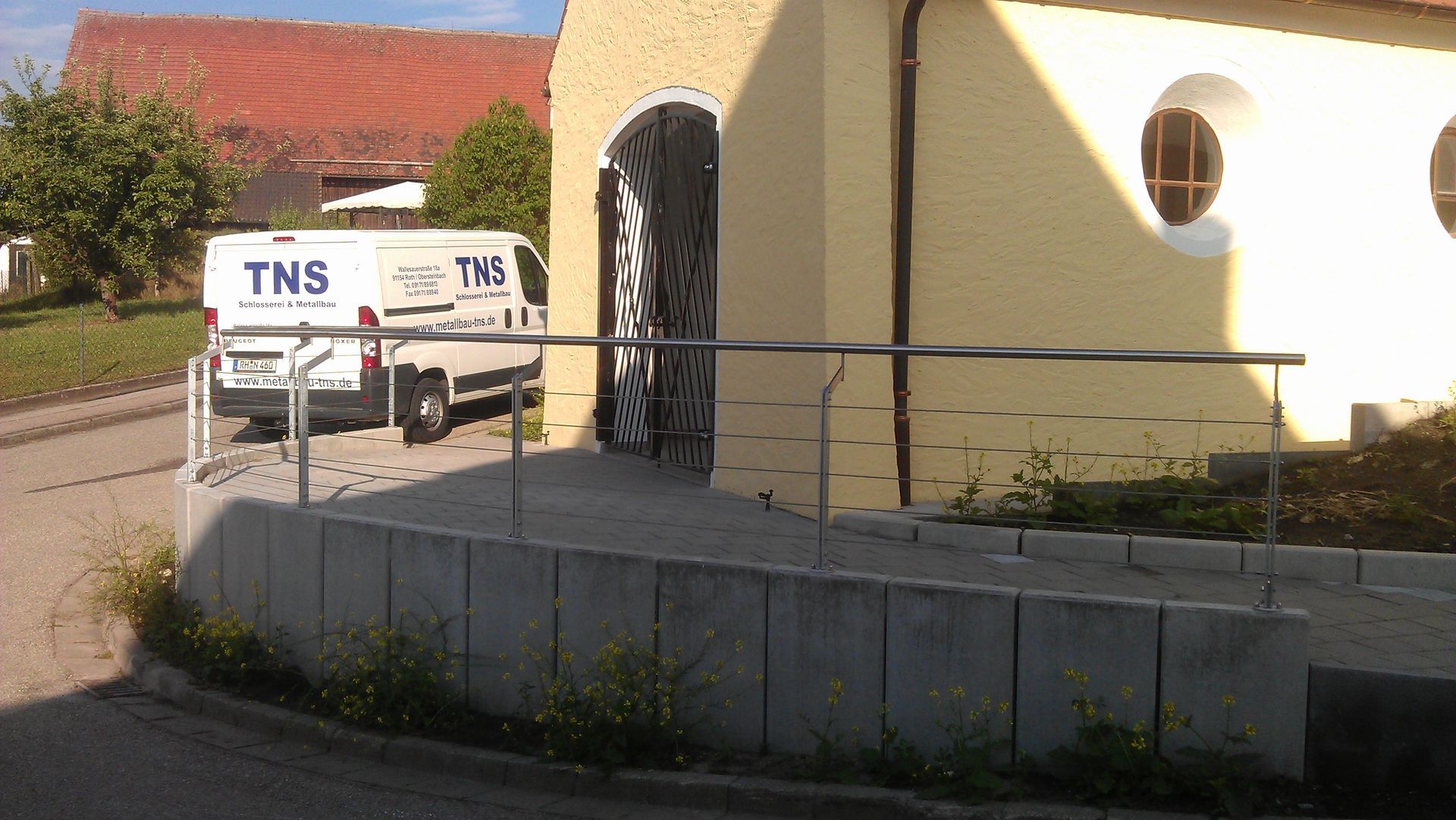 Geländer eines barrierefreien Rundgangs zum Eingang einer Kapelle