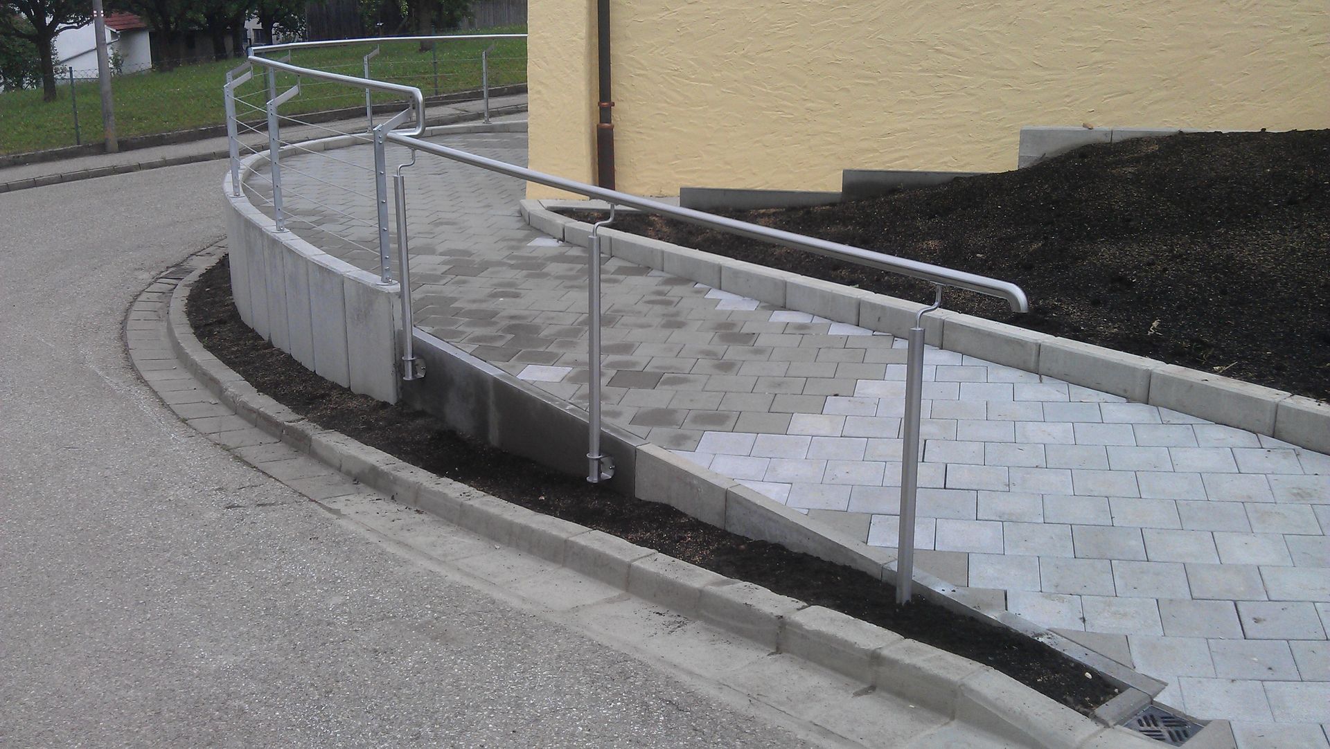 Rundes Geländer eines barrierefreien Rundgangs zum Eingang einer Kapelle