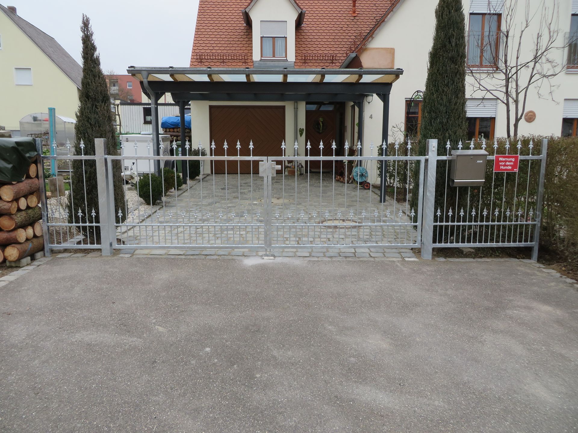 Metallzaun mit Tor und Briefkasten