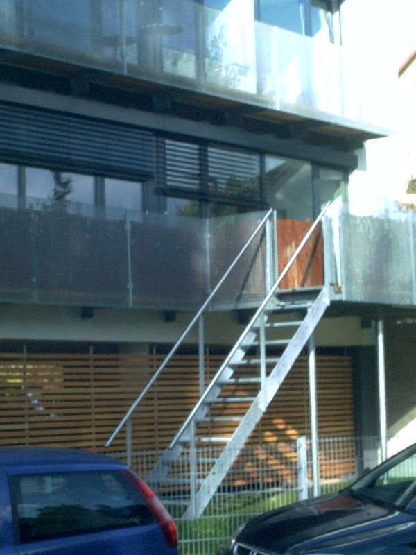 Stahltreppe zu einem nachträglich montierten Laubengang um ein Gebäude