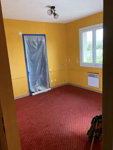 Une pièce aux murs jaunes, avec une moquette rouge.