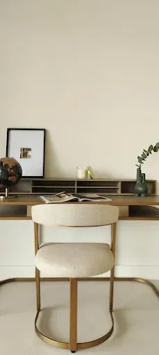 Oficina en casa minimalista con un escritorio de madera, silla blanca, cuadro enmarcado 