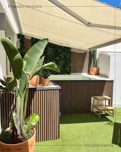 Patio trasero moderno con toldo beige, plantas tropicales en macetas y una barra elevada junto a la piscina.
