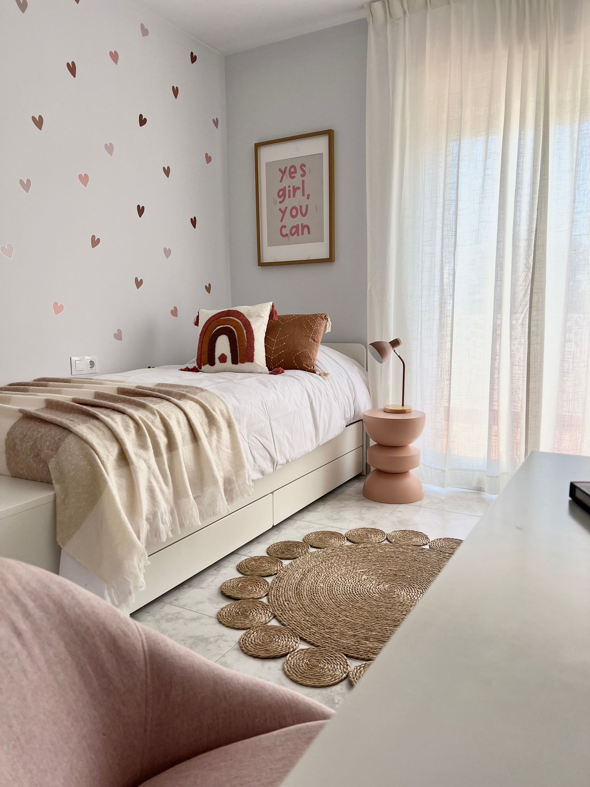 Sala de estar moderna y luminosa con sofá modular beige, mesa de centro de madera, lámpara de pie y cuadros en la pared.