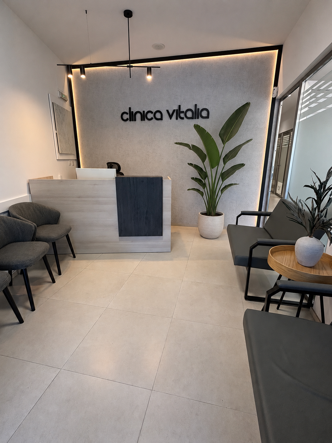 Consultorio minimalista con sillón de exploración beige, paredes blancas y letrero en la pared que dice “virco vicha”.