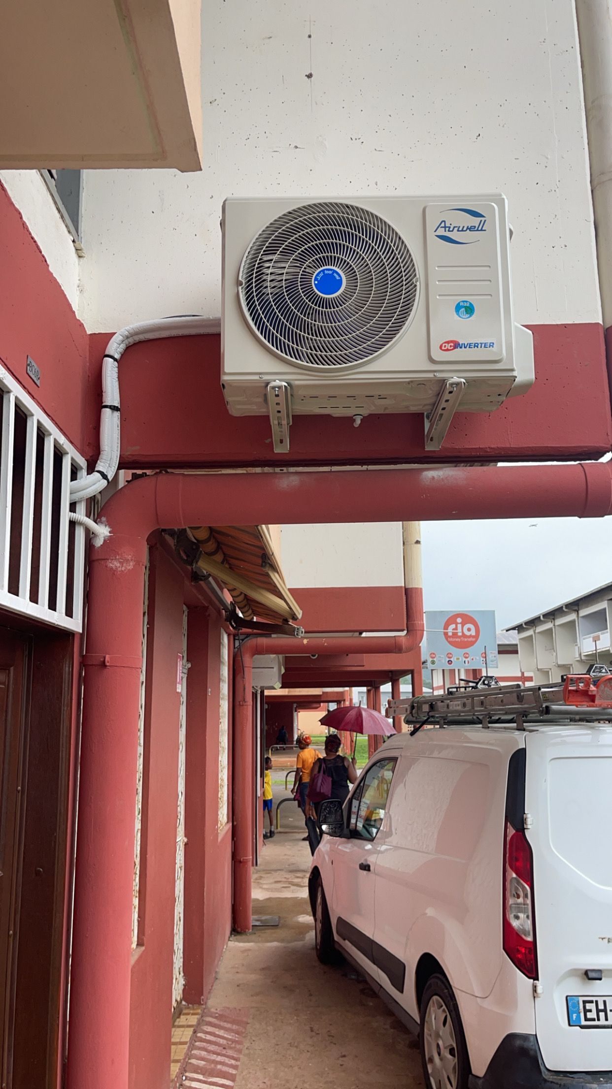 Groupe extérieur de climatisation sur une façade rouge