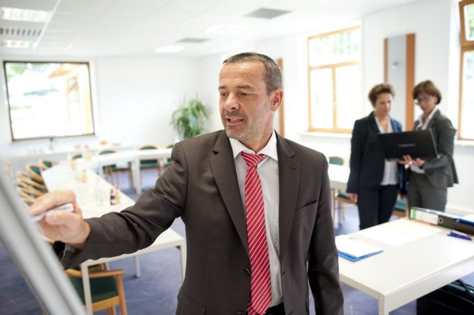 Mann zeichnet etwas auf einem Board ein in einem Meetingraum vom Landgasthof Zum Wolfsberg