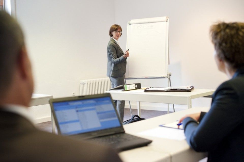 Frau präsentiert etwas in einem Meetingraum vom Landgasthof Zum Wolfsberg