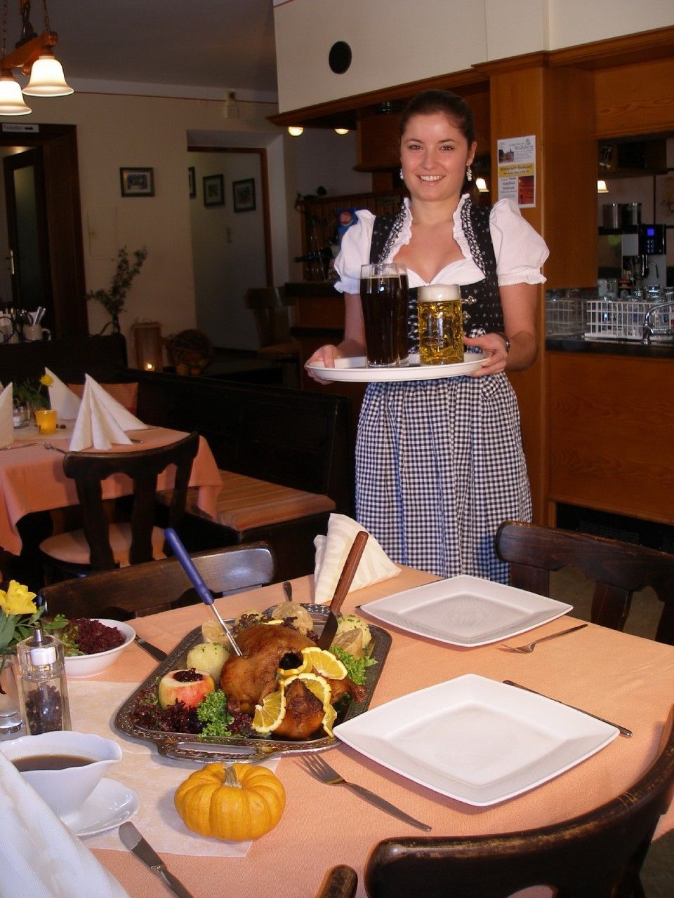Kellnerin bringt Bier zum Tisch im Landgasthof zum Wolfsberg