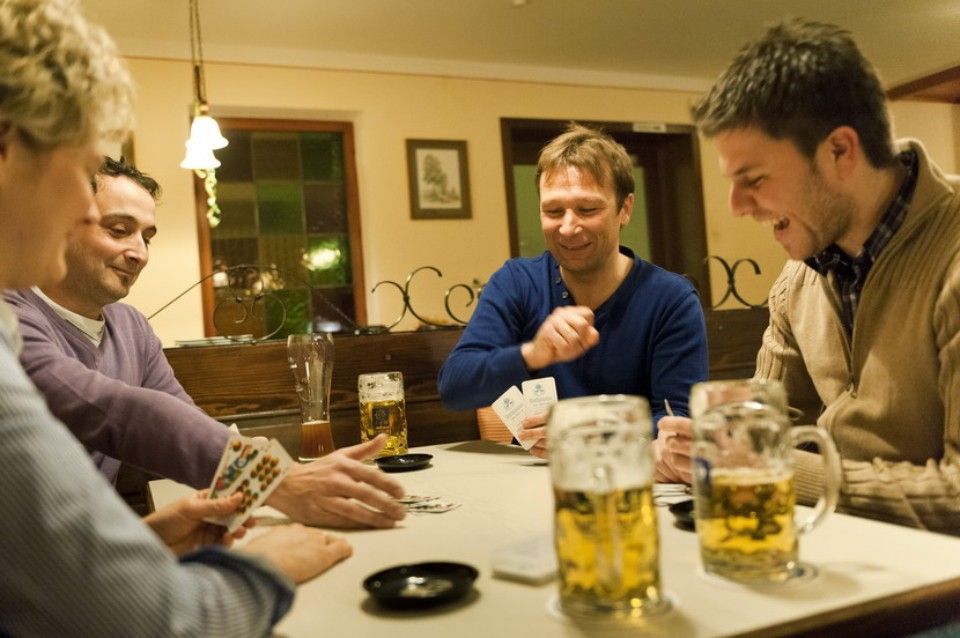 Personen sitzen am Tisch in geselliger Runde im Landgasthof zum Wolfsberg