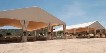 Un grupo de tiendas de campaña están situadas encima de una playa de arena.
