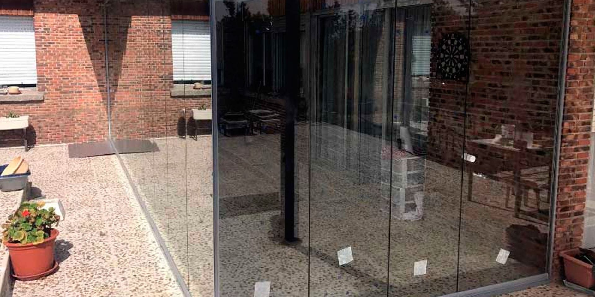 Un edificio de ladrillo con una puerta de vidrio que conduce a un patio.